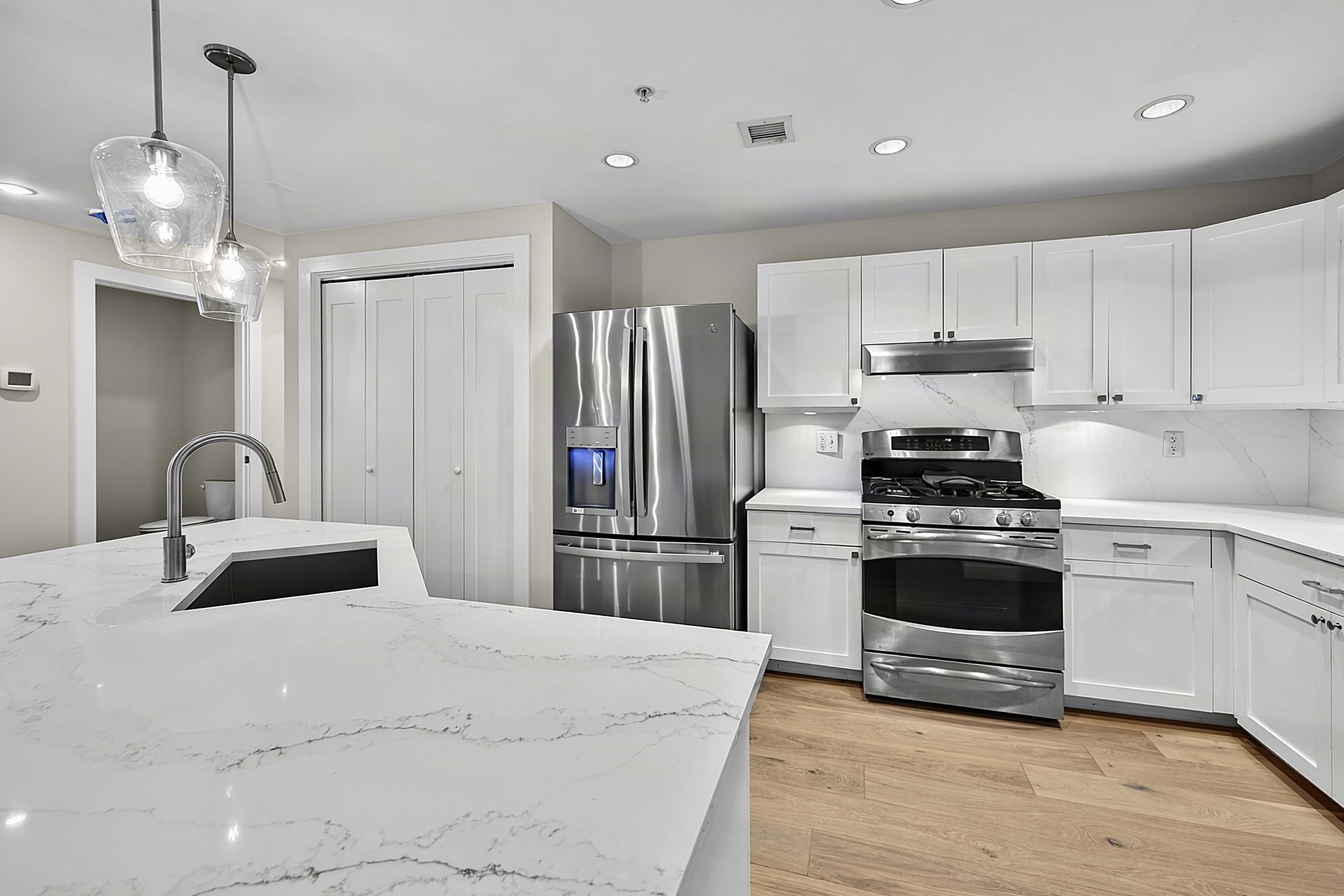 Kitchen worktop, white cabinets, and stainless steel appliances
