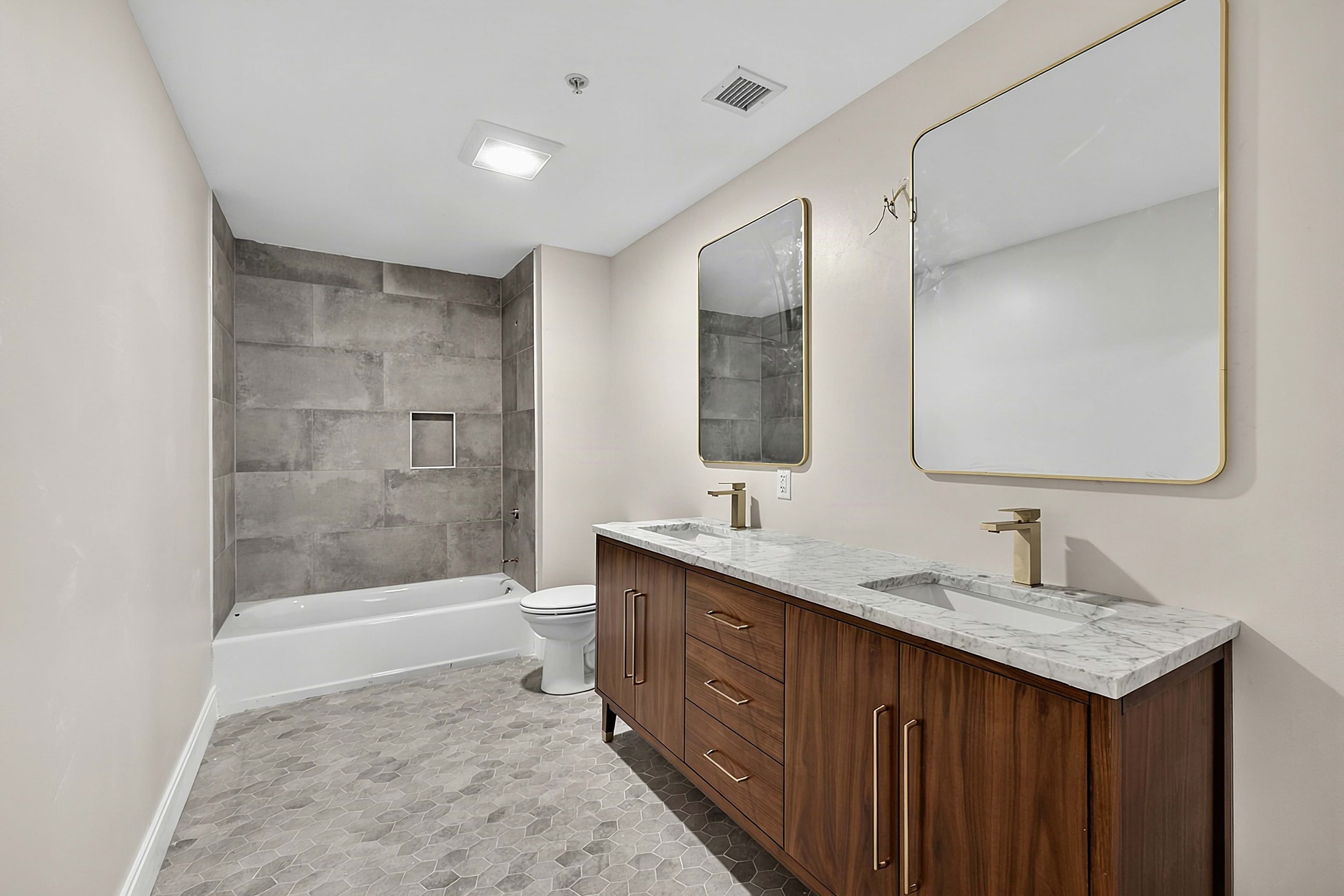 Bathroom with a double vanity and tiled bathtub